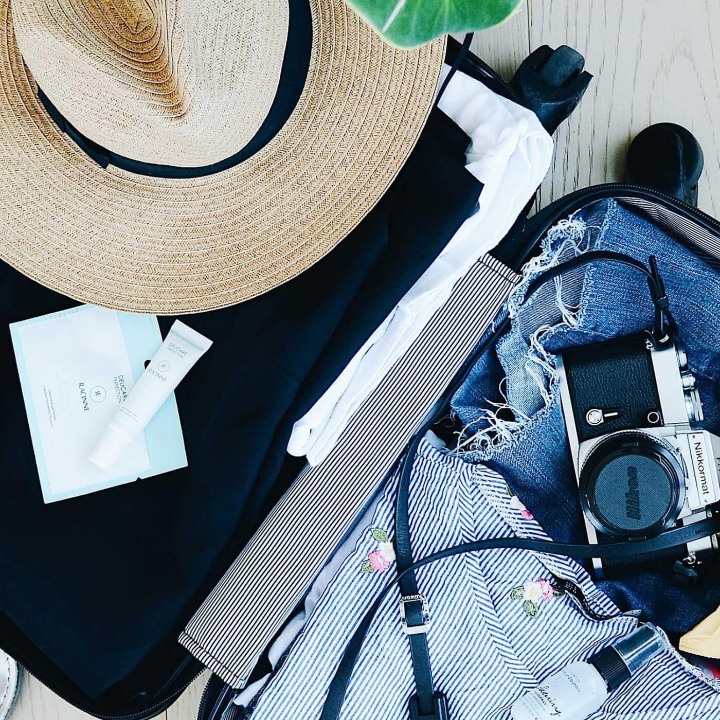An open suitcase full of clothes and travel supplies.