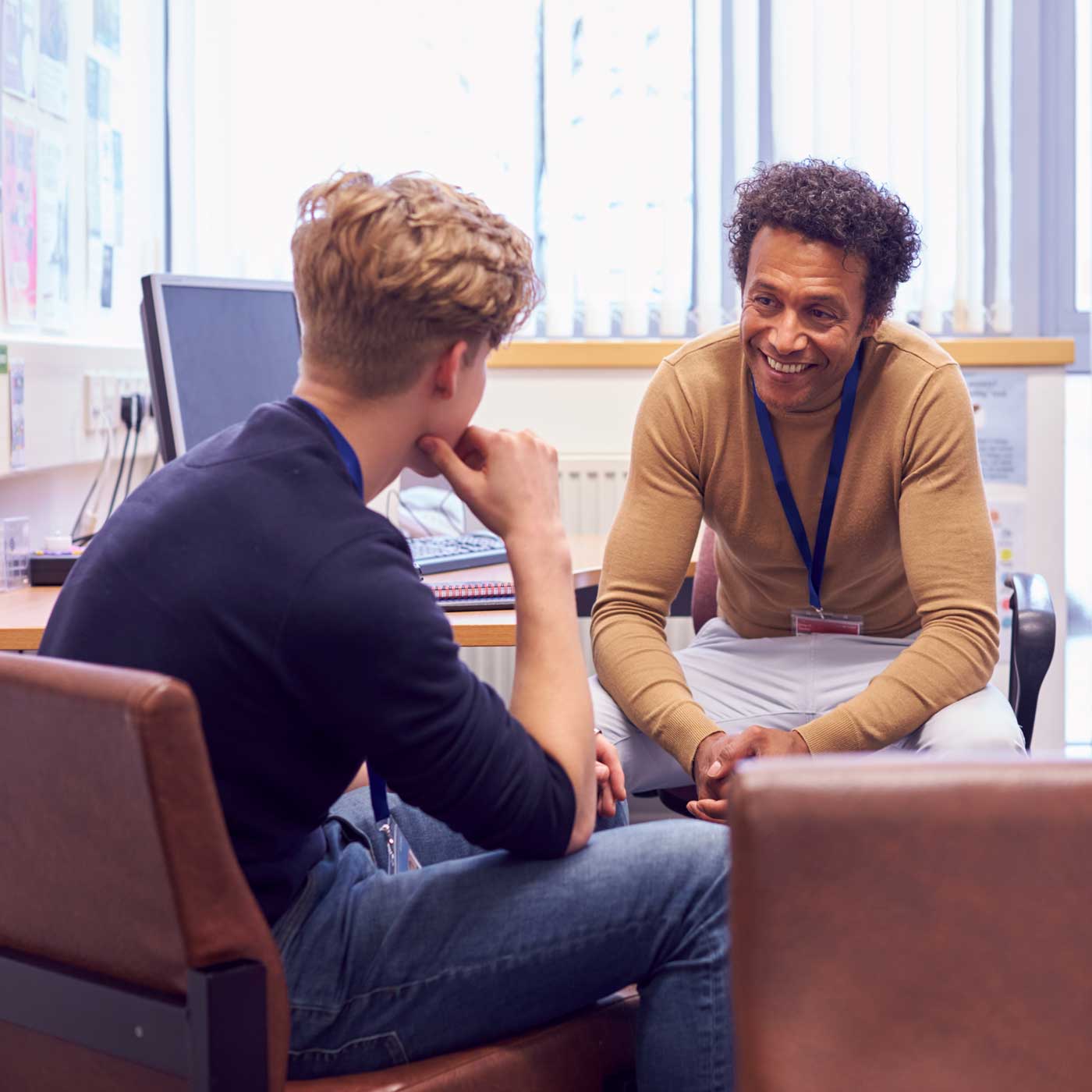 A counselor smiling and talking to a student